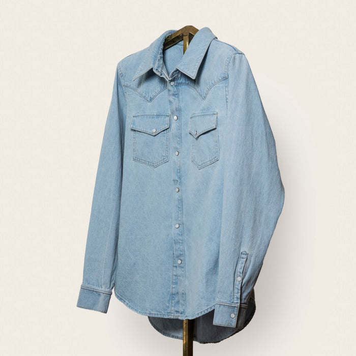Light blue denim shirt on a hanger against a white background